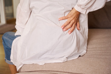 Sick female suffers from back pain