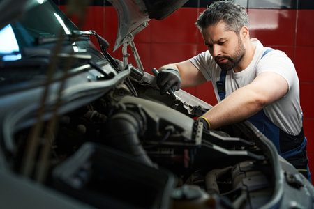 Experienced auto mechanic repairing his client car