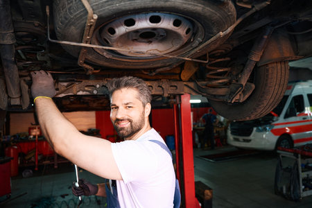 Smiling happy automotive service technician conducting motor vehicle checkの写真素材