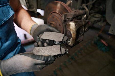 Skilled auto repair technician replacing automotive braking system partsの写真素材