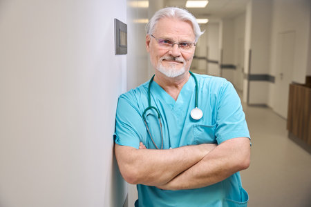 Pleased doctor is posing for camera in hospital corridorの写真素材