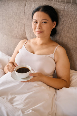 Adult woman is enjoying her espresso in morningの写真素材
