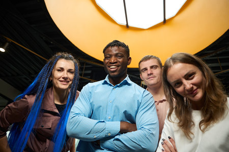 Happy mixed-raced colleagues laughing looking at cameraの写真素材