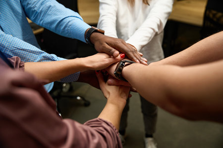 Multiethnic people putting hands on each other, preparing for new projectの写真素材