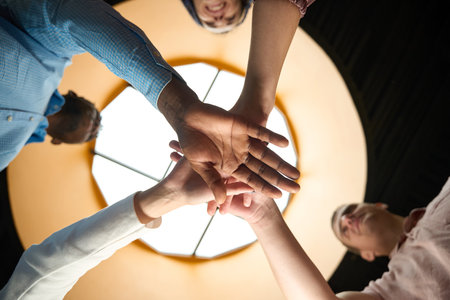 Dedicated team putting hands together as symbol of friendly teamの写真素材