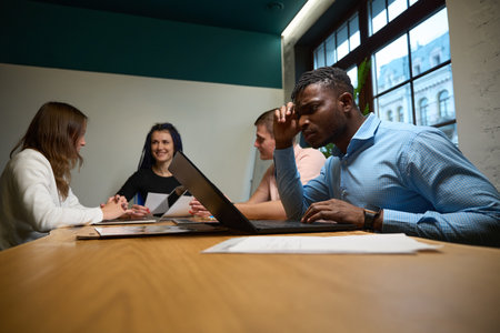 African American man concentrating his attention on project on laptop