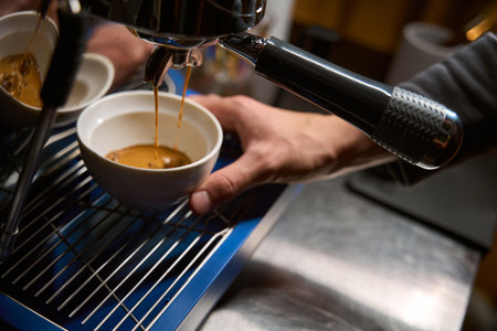Barista pouring espresso from coffee machineの写真素材