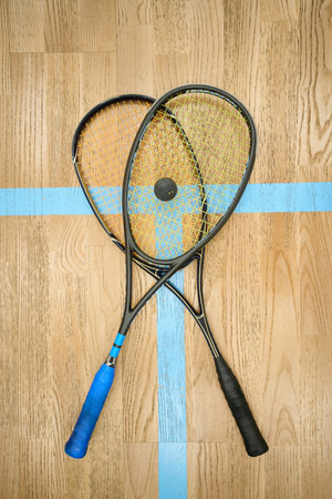 Rocket with ball on beige squash indoor court copy spaceの写真素材