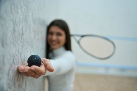 Closeup of woman hand holding squash ballの写真素材