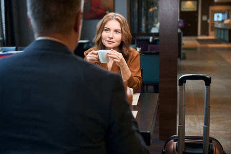 Peaceful woman with cup sitting in front of a manの写真素材