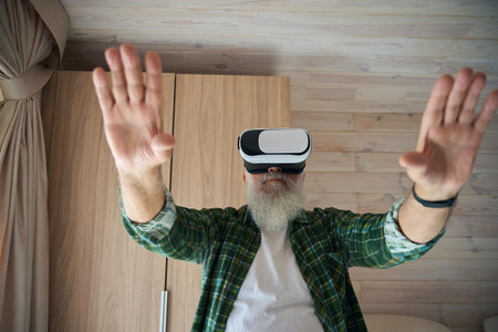 Gray-bearded old man in virtual reality glassesの写真素材
