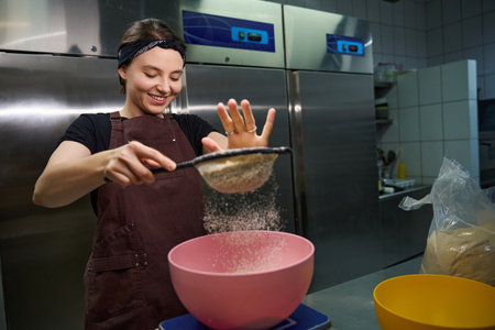Cheerful young pastry chef is preparing and weighing baking ingredients