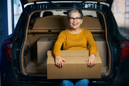 Smiling lady with short hair sitting on trunkの写真素材