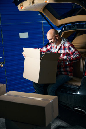 Man looks into a cardboard box with things
