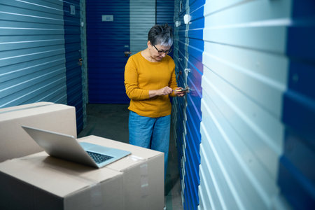 Woman opens storage locker next to boxesの写真素材