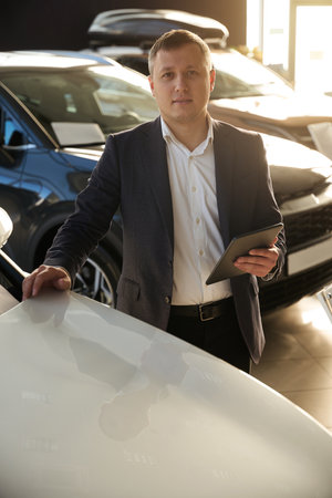 Dealer watching with camera next to car