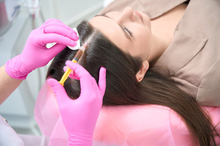 Professional beautician on cosmetology procedure with femaleの写真素材