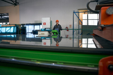Employee uses automatic table for cutting glass in window productionの写真素材
