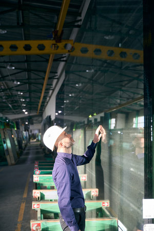 Engineer inspects glass in a production workshopの写真素材