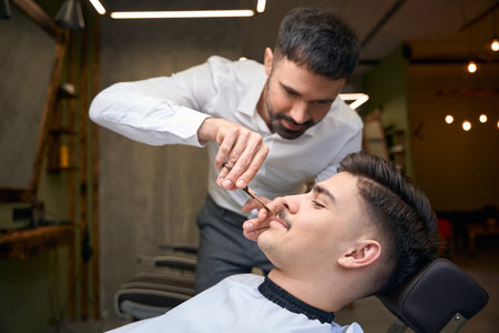Coiffeur cutting male customer mustacheの写真素材