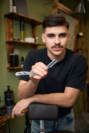 Man barber with razor in hands in barbershop