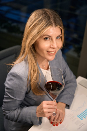 Smiling lady enjoying red wine