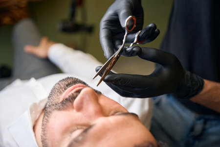 Bearded man getting beard haircut at barbershopの写真素材
