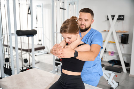 A professional osteopath straightens the spine of a patient