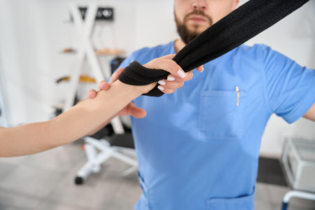 Woman does stretching exercises under the supervision of a kinesiologistの写真素材