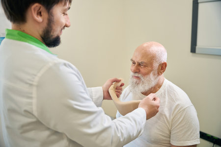 Neurologist doctor puts a protective collar on a patient neckの写真素材