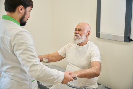 Male doctor examining an old patient in his officeの写真素材