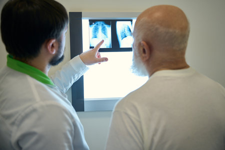 Patient and doctor looking at chest x-rayの写真素材