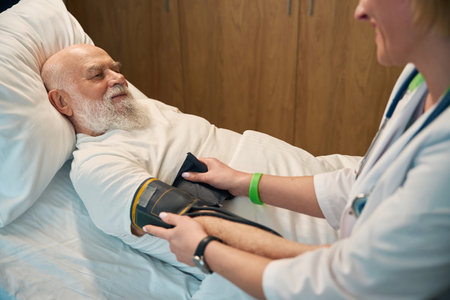Old patient lying on a hospital bed in the ward