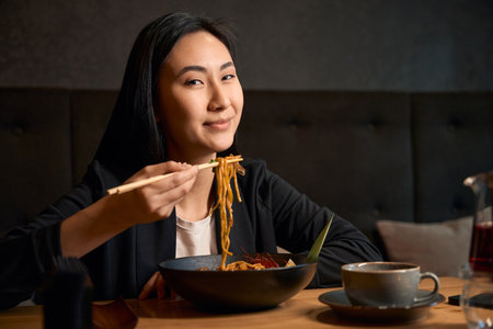 Beautiful Asian girl visiting new restaurant to try delicious meal