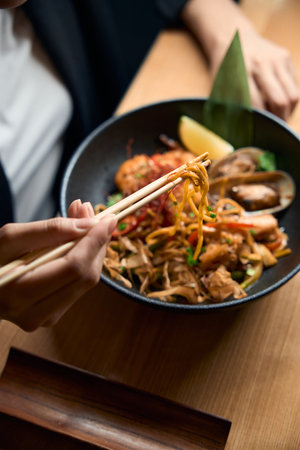 Top view woman holding ramen noodles with chopsticksの写真素材