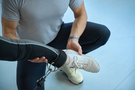 Physiotherapist trainer works with a patient on a special simulator