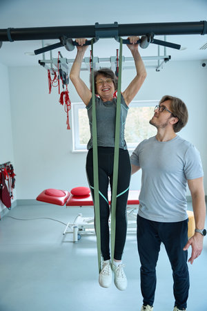 Physiotherapist conducts rehabilitation exercises on the suspension system
