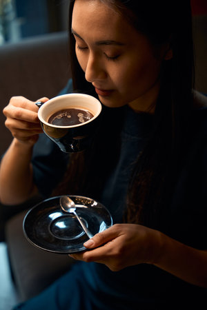 Woman in blue dress enjoying aroma of fresh brewed coffeeの写真素材