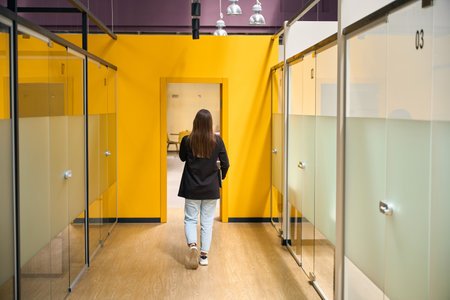 Woman enters the office from the corridorの写真素材