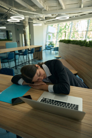 Tired woman lowered her head to her deskの写真素材