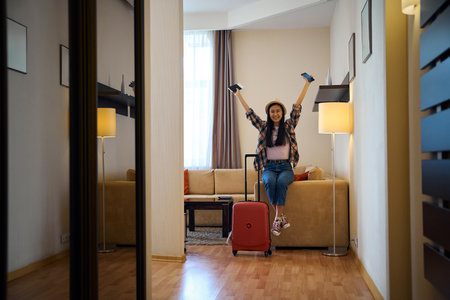 Female tourist rejoicing at her arrival at luxury suiteの写真素材