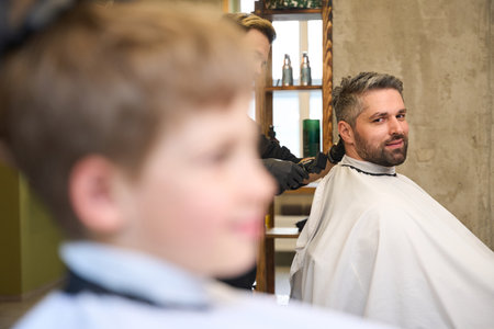 Father and son spending time together making appointment with hairdresserの写真素材