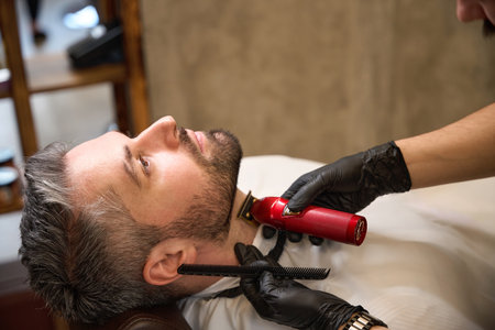 Barber modeling neckline with help of trimmer without a guard
