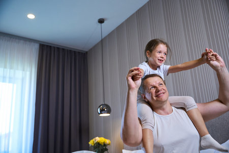 Dad wakes up his little daughter in the morningの写真素材