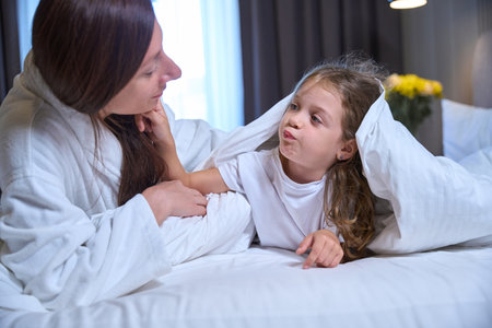 Woman in a terry robe communicates with her little daughterの写真素材