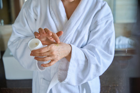 Senior female putting cream on the hand with her fingerの写真素材