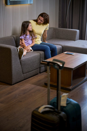 Mom and daughter are sitting on a soft sofaの写真素材