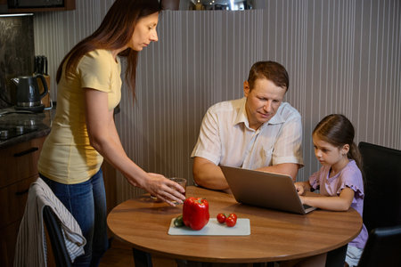 Man and his daughter are busy with a laptopの写真素材