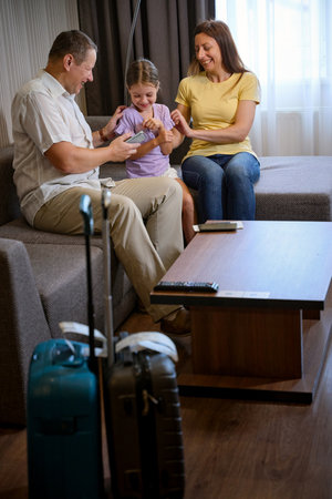 Parents and daughter are sitting on cozy sofaの写真素材