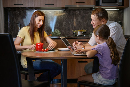 Happy family gathered at the table in a hotel roomの写真素材